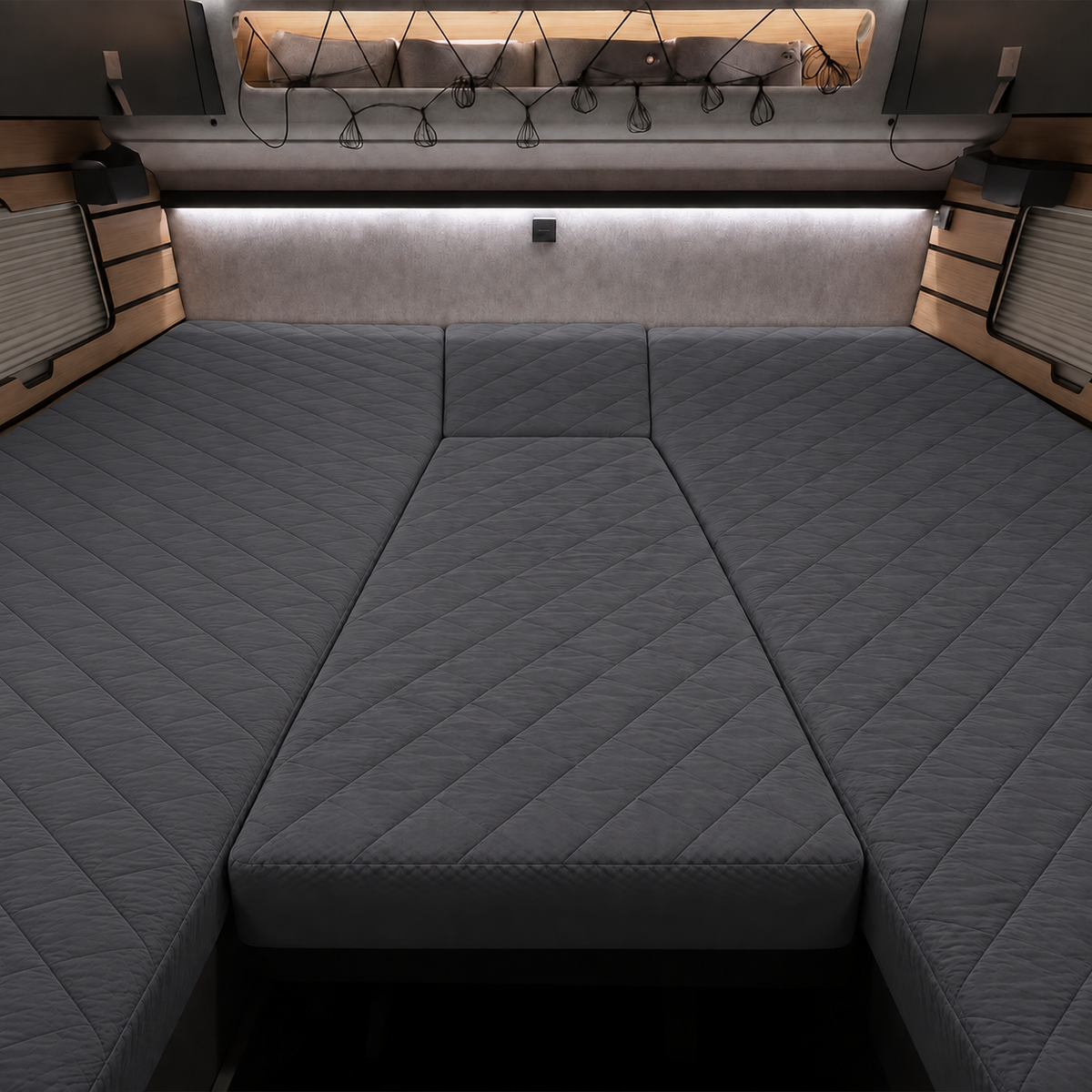 A dark gray quilted camper bed frame with a diamond-stitched pattern, shown from a top-down perspective inside a vehicle or van.