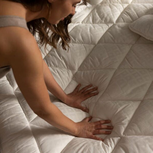 Person touching a mattress to check its comfort