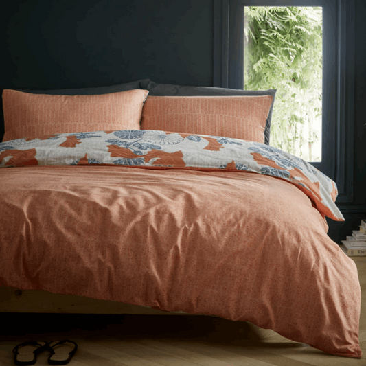 Koi fish gracefully float above an ornamental tiled floral background. An invigorating colour palette of mandarin orange and cool sky blue features over a chalk white ground