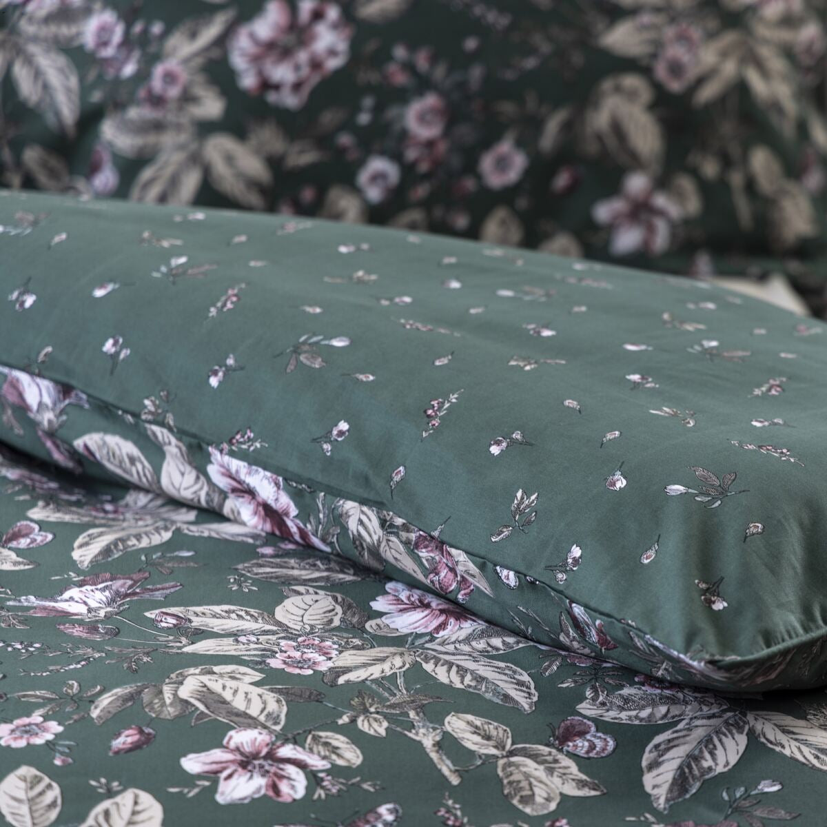 Floral-patterned bed sheets on a bed with a nightstand in the background.