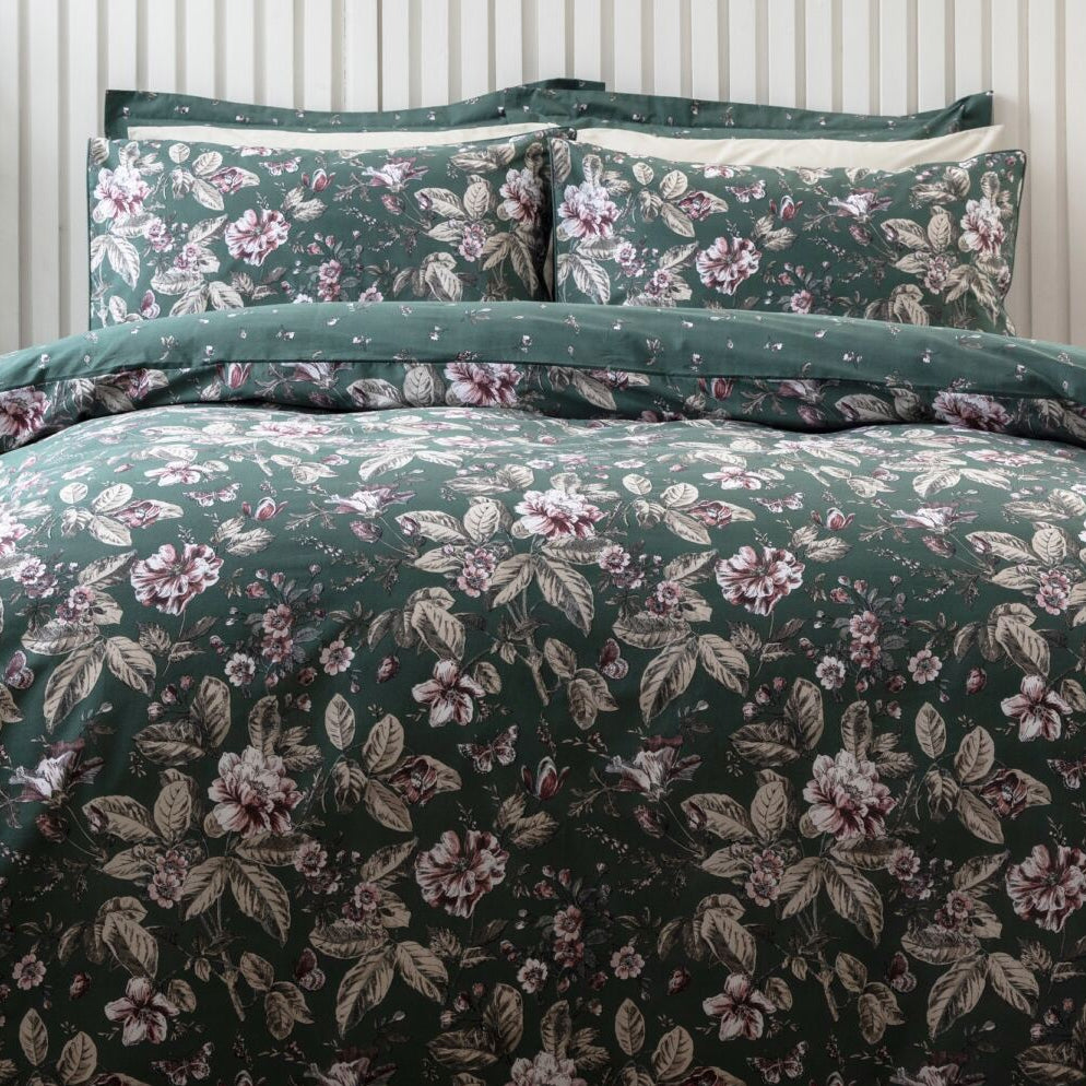 Floral patterned bedding set on a bed with matching curtains in a bedroom setting.