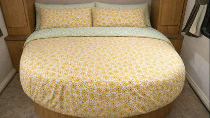 Round bed with yellow floral bedding in a compact living space
