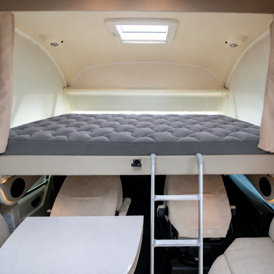 Motorhome drop down overcab bed with grey padded protector