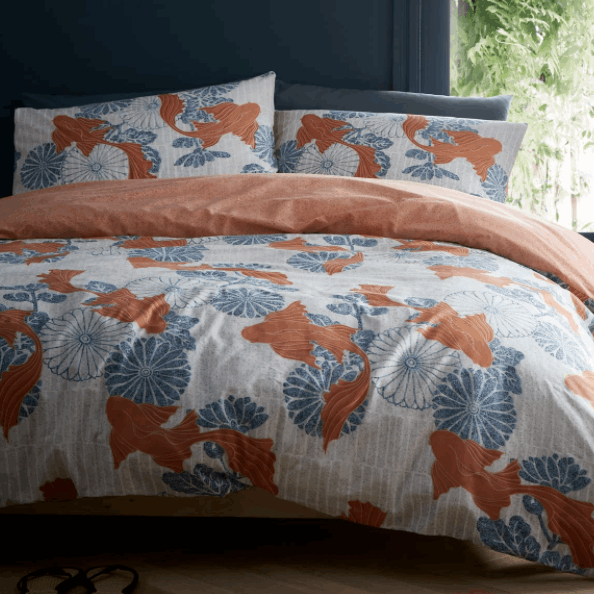 Koi fish gracefully float above an ornamental tiled floral background. An invigorating colour palette of mandarin orange and cool sky blue features over a chalk white ground