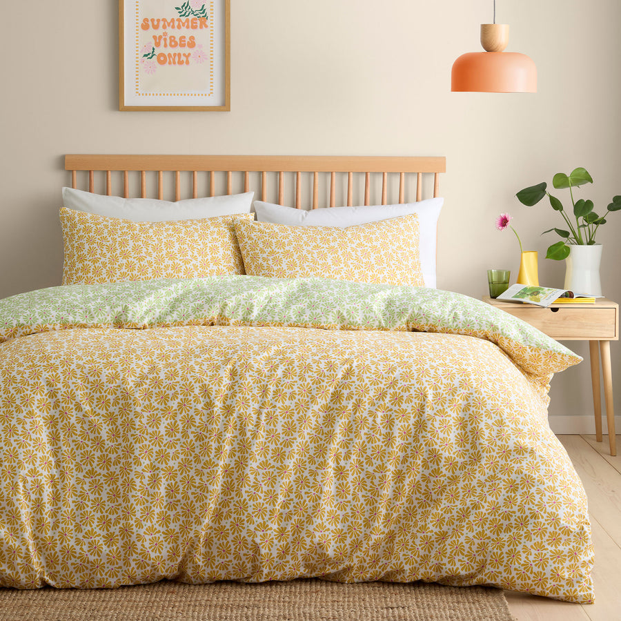 Bedroom with yellow floral bedding and a wooden headboard.