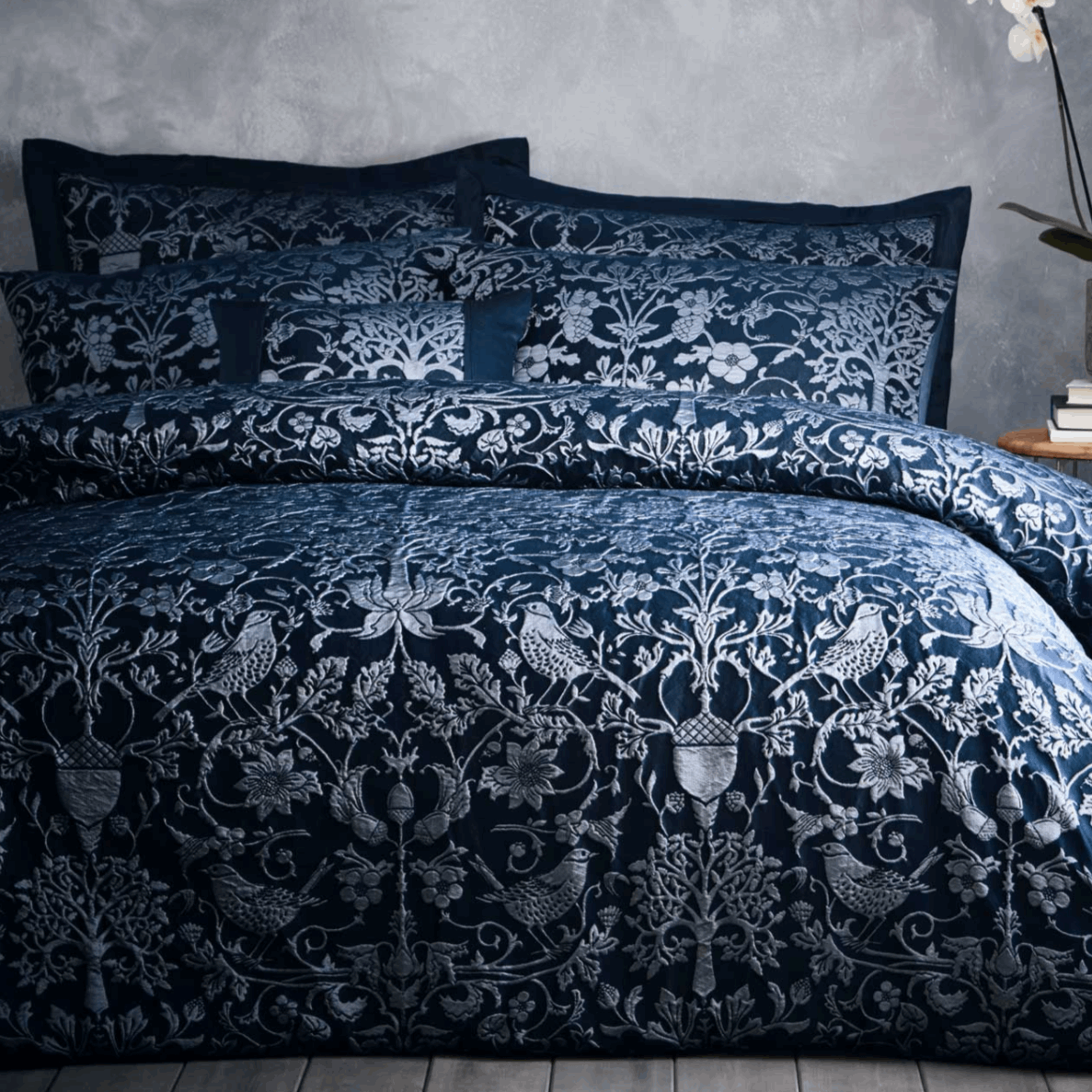 Featuring hand-drawn natural elements and simple woodblock shapes all produced in a high quality woven relief jacquard in a deep Navy colour palette